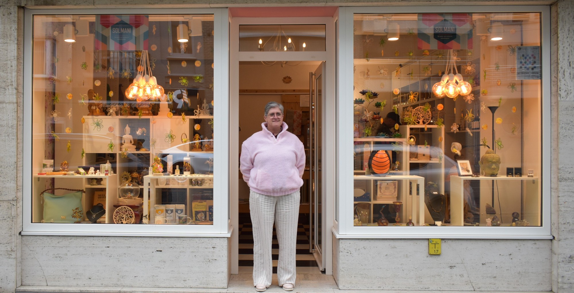 Een hoek van de winkel Solmani met edelstenen, kaarsen en sieraden in zacht licht